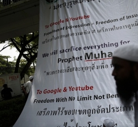 Muslim protesters unwrap a large banner in front of the U.S. embassy in Bangkok that encourages Youtube to remove the video.