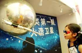 A Chinese girl takes a close look at the world's first artificial satellite, the Soviet-made Sputnik I, at a Russian space exhibit in the southern Chinese city of Guangzhou June 16, 2002.